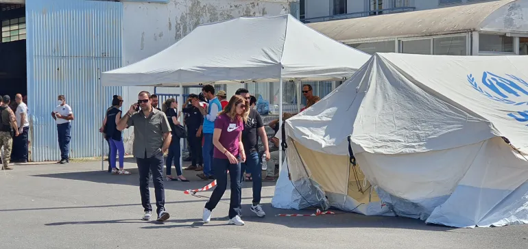 Aid workers outside the warehouse in Kalamata where survivors were being kept [John Psaropoulos/Al Jazeera]