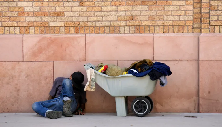 A homeless man sleeps against the wall of a building along 14th Street as temperatures soar on Friday, August 4, 2023, in Downtown Denver, Colorado, US [David Zalubowski/AP Photo]