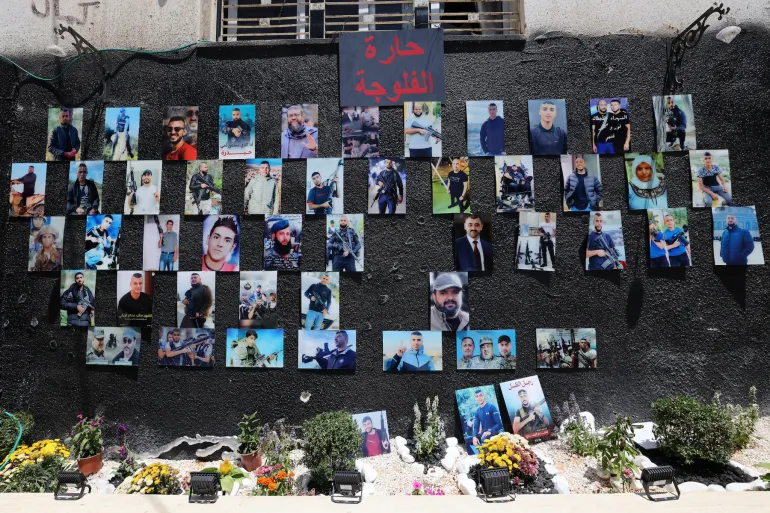 Portraits of people who were killed during the Israeli-Palestinian conflict in the occupied West Bank city of Jenin hang on a wall on July 5, 2023 [File: Ahmad Gharabli/AFP]