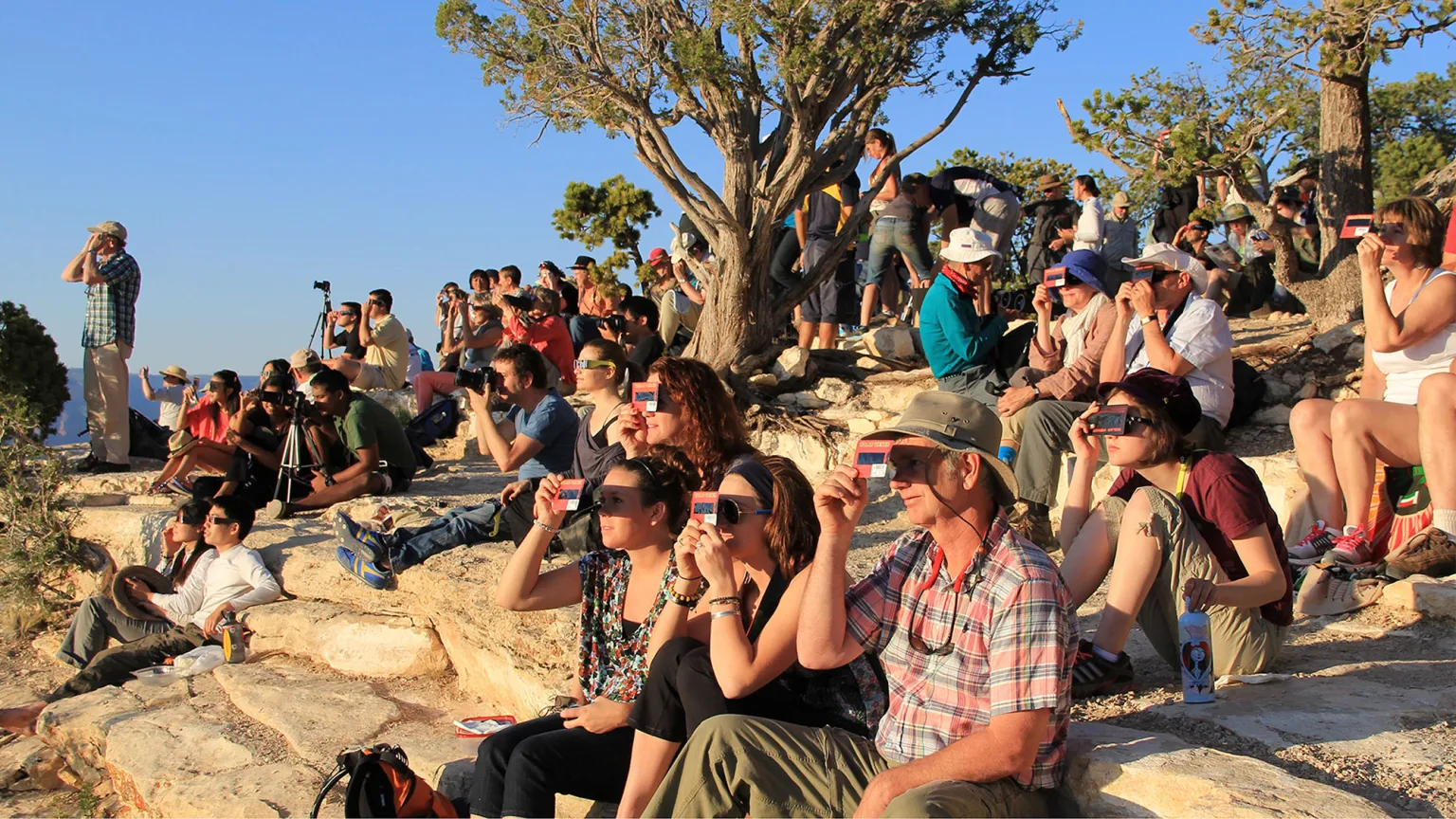 https://dazzlingdawn.com/wp-content/uploads/2024/04/A-crowd-uses-handheld-solar-viewers-and-solar-eclipse-glasses-to-safely-view-a-solar-eclipse.webp