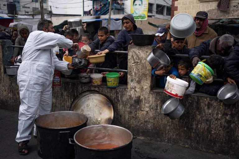 https://dazzlingdawn.com/wp-content/uploads/2024/04/Palestinians-line-up-for-free-food-in-Rafah-Gaza-Strip-amid-warnings-of-famine-across-the-region-AP.jpg